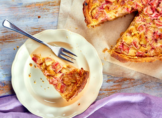Homemade pie with rhubarb and custard on wooden table