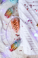 Obraz na płótnie Canvas Christmas toys with a garland on a knitted sweater