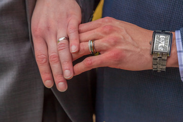 male hands and wedding rings from gay wedding