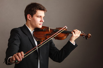 Man man dressed elegantly playing violin