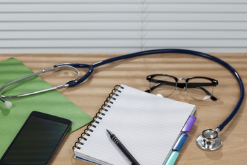 Stethoscope and a notepad laying on a doctors desk