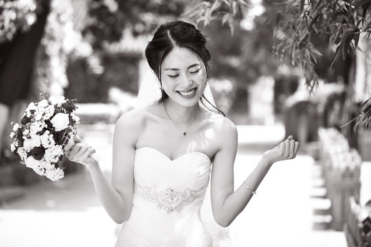 asian bride rejoicing with bouquet in hand
