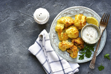 Oven baked cauliflower with yogurt sauce.Top view with copy space.