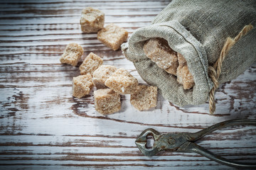 Stack of vintage brown sugar pliers sack on wooden board