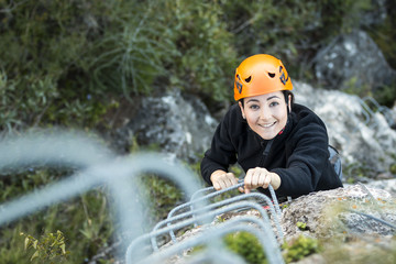 Woman climbing up a via ferrata