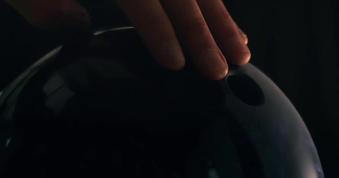 Male hand coming down and picking up a tenpin bowling ball