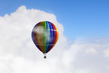 Aerostat floating in day sky. Mixed media