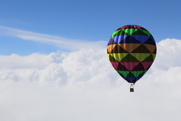 Aerostat floating in day sky. Mixed media