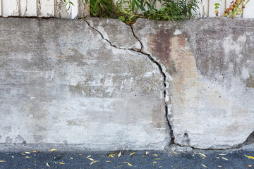 Big crack in messy outdoor concrete wall