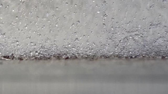 Fountain Rain Drops. Slow movement of the surface of the water splashes a river or pond. Heavy rain or working fountain. Drops of water fall down the macromolecule