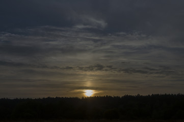 Obraz premium Sundown and sunrises. Dark blue sky with much clouds. Silhouettes of trees far away. Background of heaven. Beautiful evening 