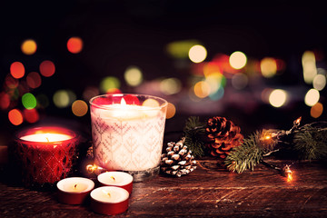 Christmas background - Christmas candle and rustic decoration on wood table with christmas lights background in night party. vintage color style.