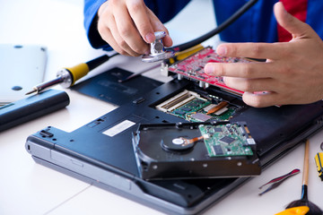 Obraz premium Repairman working in technical support fixing computer laptop tr
