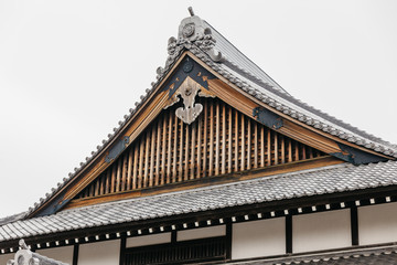 Fototapeta na wymiar Close up detail roof of Edo period architecture style with leaves less tree in Noboribetsu Date JIdaimura Historic Village at Hokkaido, Japan.