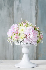 Floral arrangement with pink peonies, tiny roses, chrysanthemums and gypsophila paniculata twigs