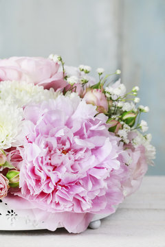 Floral arrangement with pink peonies, tiny roses, chrysanthemums and gypsophila paniculata twigs