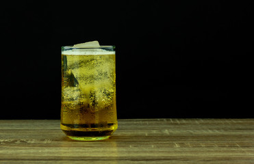 Glass beer on wooden table with black background