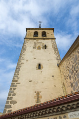 Fototapeta na wymiar Bell tower of the San Andres Church, in Rascafria, Madrid, Spain. It was built in the XV century