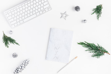 Christmas home office desk with computer, notebook, pine branches, christmas silver decorations. Flat lay, top view, copy space