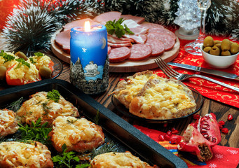 Christmas baked chops with cheese and cold cuts platter, served on the old wooden table
