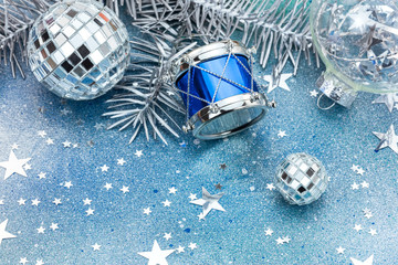 decorative christmas tree balls with spangles and silver drum on blue background with confetti