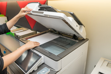 Women copying paper from Photocopier with access control for scanning key card