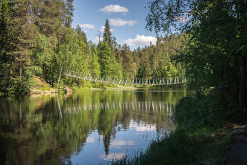 Fototapeta na wymiar Rope bridge across the river in Lapland.