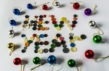 Many different buttons. Buttons for clothes made of plastic. View from above. The buttons write a new year.