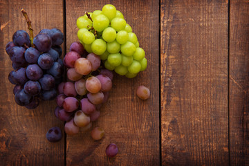 Harvest season. Fresh harvested red, black and white (green) grapes on a table.