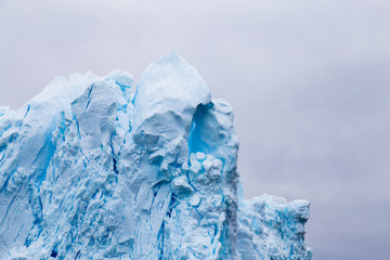 A huge iceberg has calved from a glacier. Showing beautiful blue ice