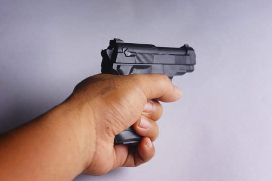 Hand Holding Handgun Isolated Over White Background