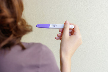 Woman holding pregnancy test, New life and family planning concept.