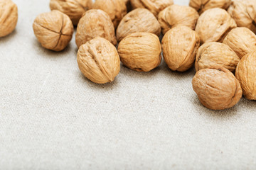 Background of nuts on light textile surface with copy space. Selective focus.