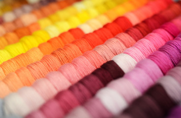 Multicolor sewing threads background. Shallow depth of field