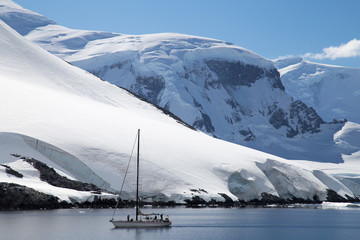 A sailing ship sails through the neumayer channel, Antarctica.