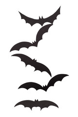 Silhouettes of volatile bats carved out of black paper are isolated on white