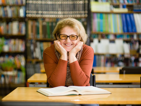 Happy senior woman in library