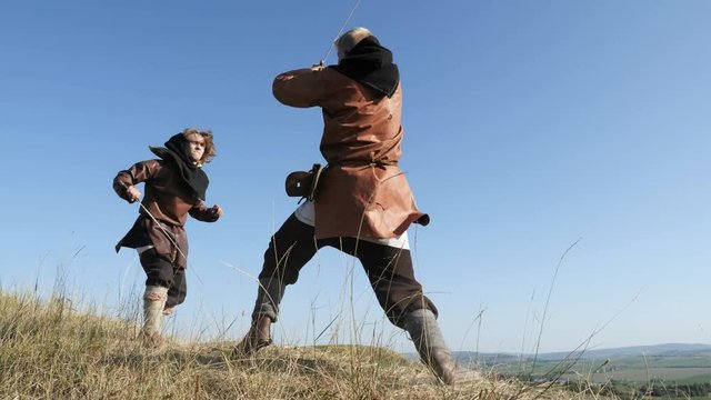 Two warriors Viking are fighting with swords