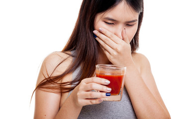 Beautiful healthy Asian girl hate  tomato juice.