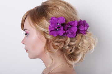 Portrait in profile of beautiful young blonde woman with flowers in her hair