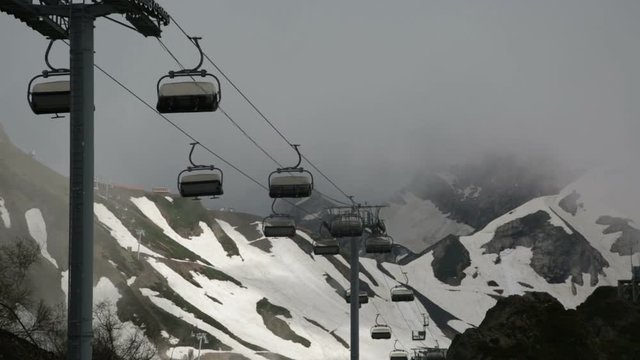 open-type cable car over snow-covered mountains 
