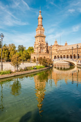 Fototapeta na wymiar North tower with reflection in river at the Place of Espana in Sevilla, Spain