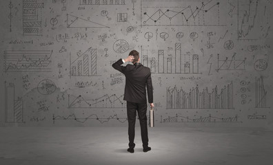 Salesman with business charts on wall