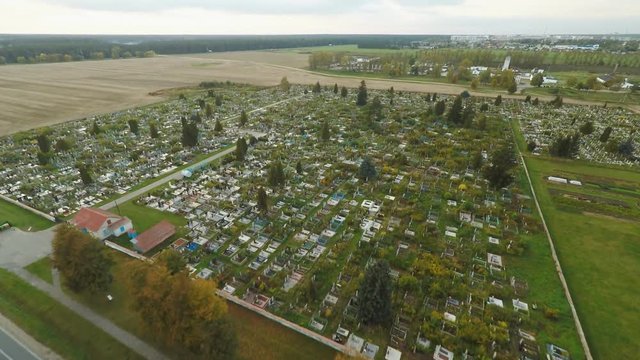 Aerial photo of cemetery graveyard showing the headstones and tombstones of the graves some are with flowers long shadows.