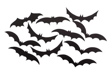 Silhouettes of volatile bats carved out of black paper are isolated on white