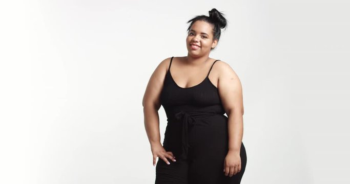 Strong confident beautiful plus size African American model in black one piece suit on white background