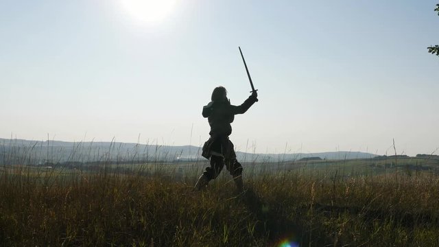 Silhouette of a Viking training using the sword for battle.