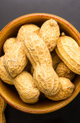 Peanuts in shell on dark background, close up
