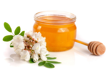 Jar of honey with flowers of acacia isolated on white background