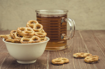 glass of tea and pretzel in a white plate/glass of tea and pretzel in a white plate on a wooden table